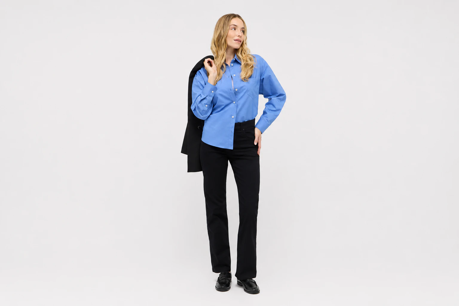 Eine schwarze Wide Leg Jeans mit hellblauer Bluse kombiniert