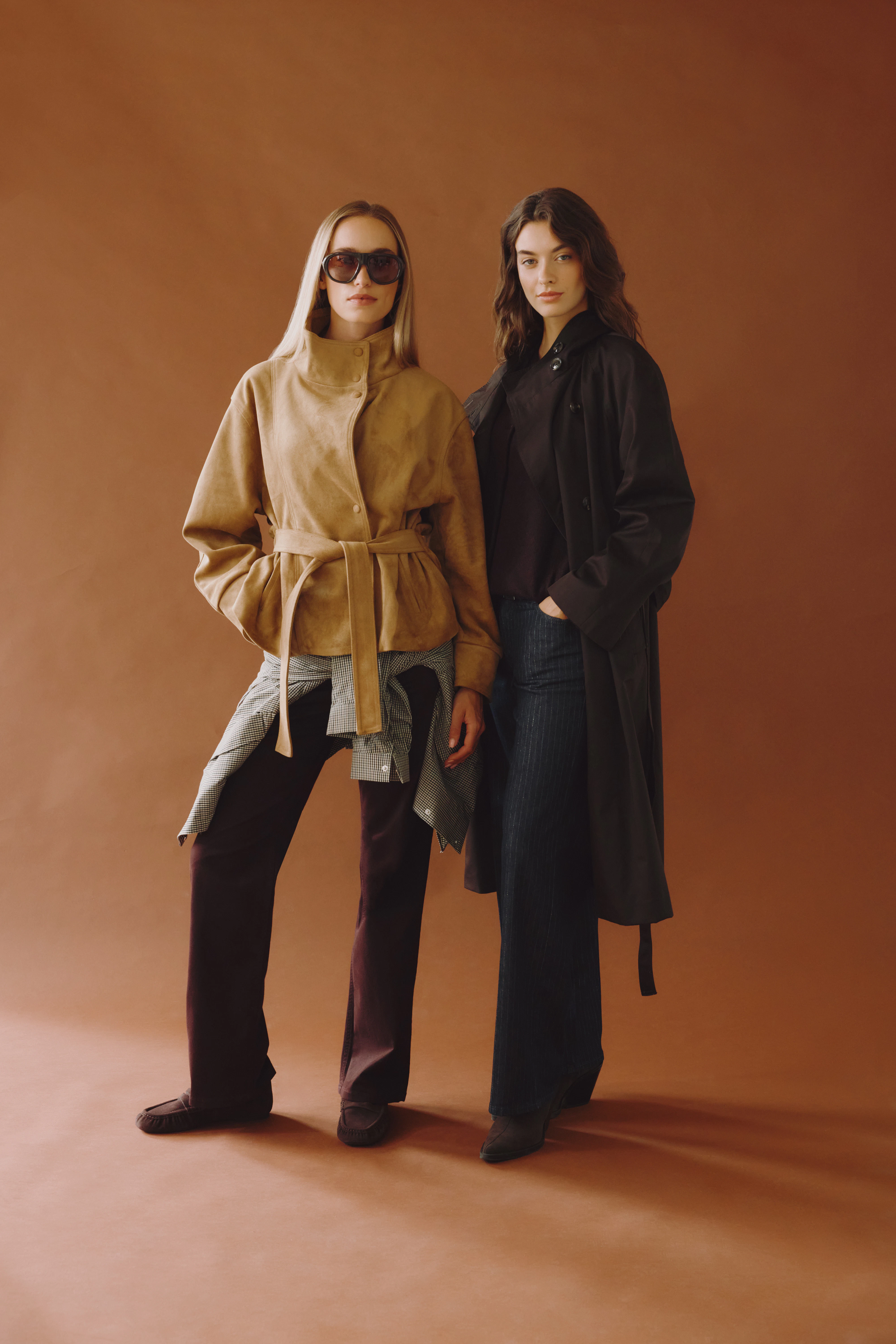 Zwei Models in eleganten Herbstlooks mit Stoffhosen, Jacken und Mantel