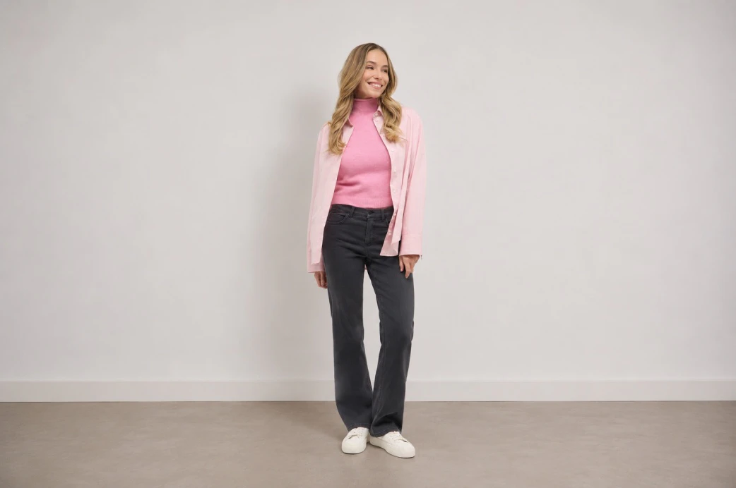 Model in grauer Wide Leg Jeans mit rosa Rollkragenpullover und Cardigan