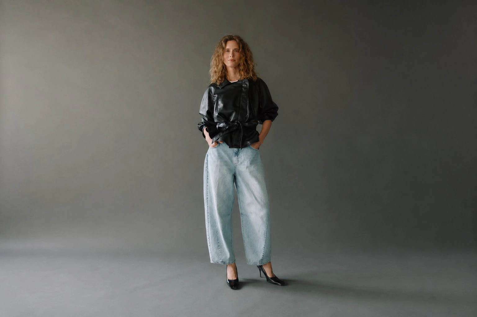 Modell trägt hellblaue Elly Barrel Jeans mit High Heels und kurzer dunkler Jacke
