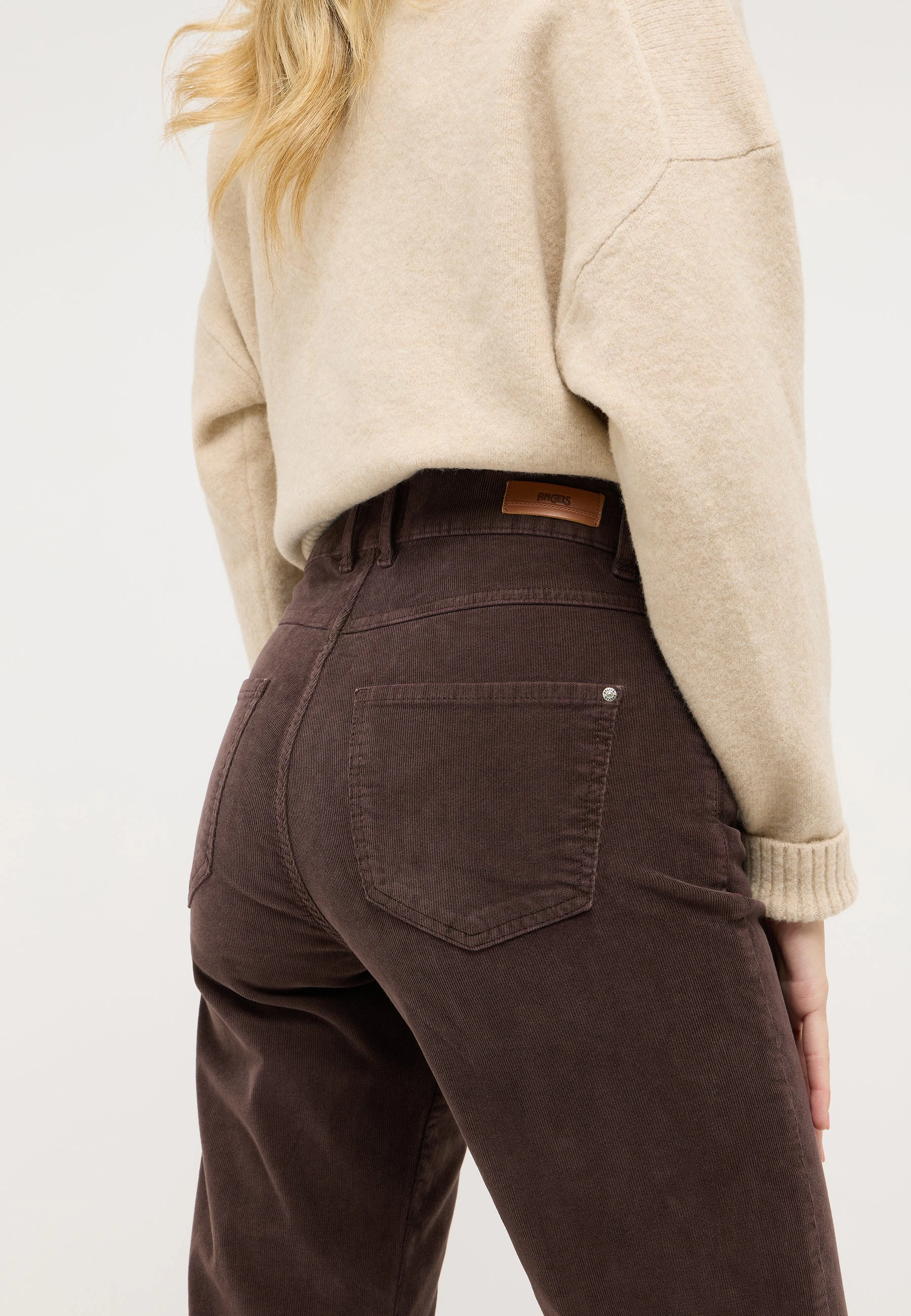 Bildausschnitt von Kombination einer braunen Cordhose mit beigen Strickpullover