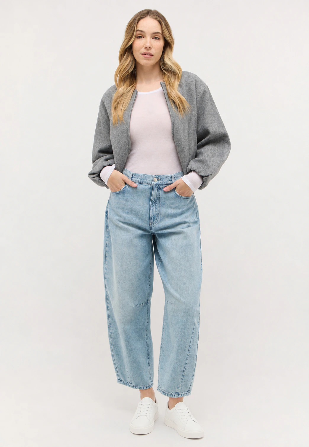 Model trägt verkürzte Barrel Jeans Elly mit Sneakern, weißem Top und Jacke