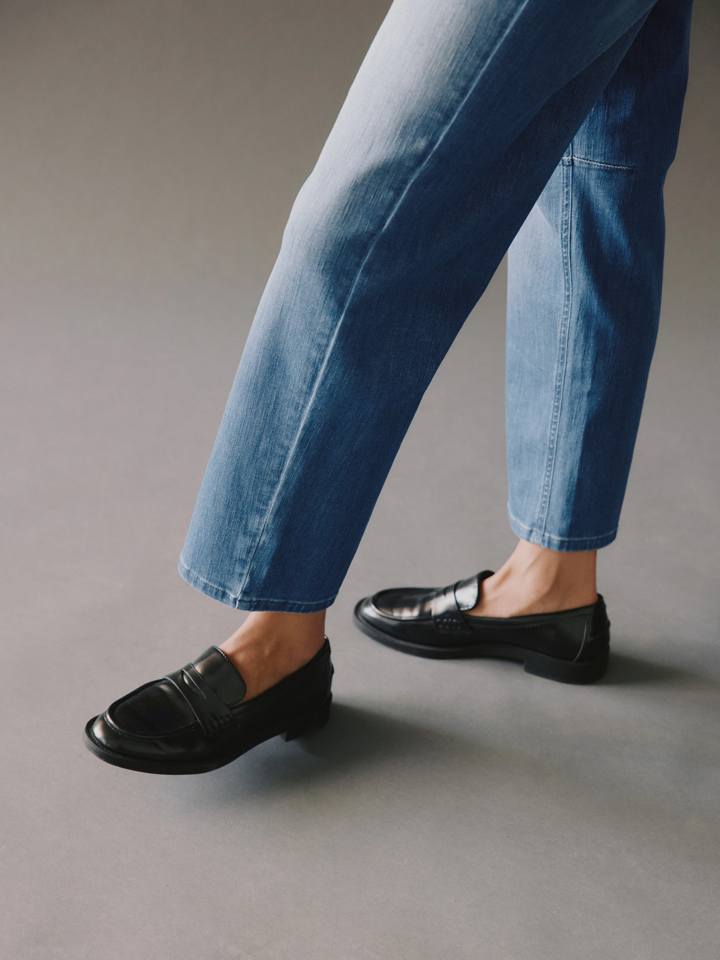 Detailausschnitt von O-Shape Jeansbein und schwarzen Loafern