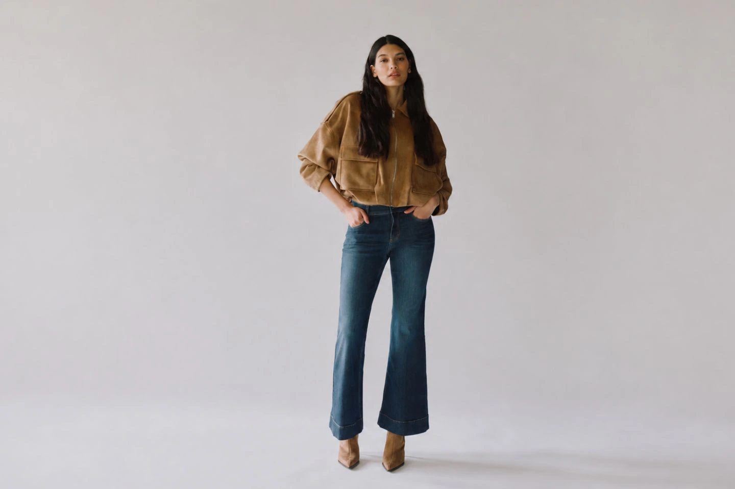 Model trägt dunkle Flared Jeans von ANGELS mit Jacke und Boots