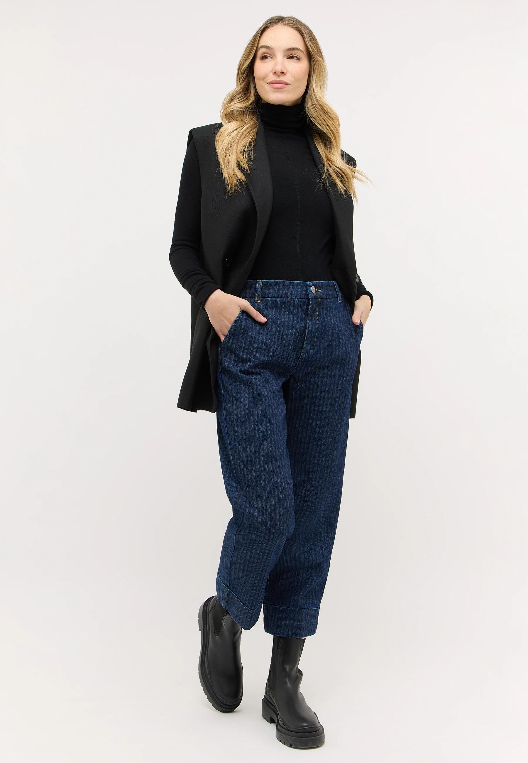 Model trägt dunkle gestreifte Jeans von ANGELS mit Blazer