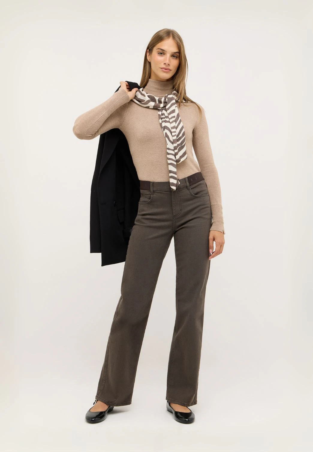 Frau trägt braune Wide Leg Jeans mit Stretch-Bund und Rollkragenpullover