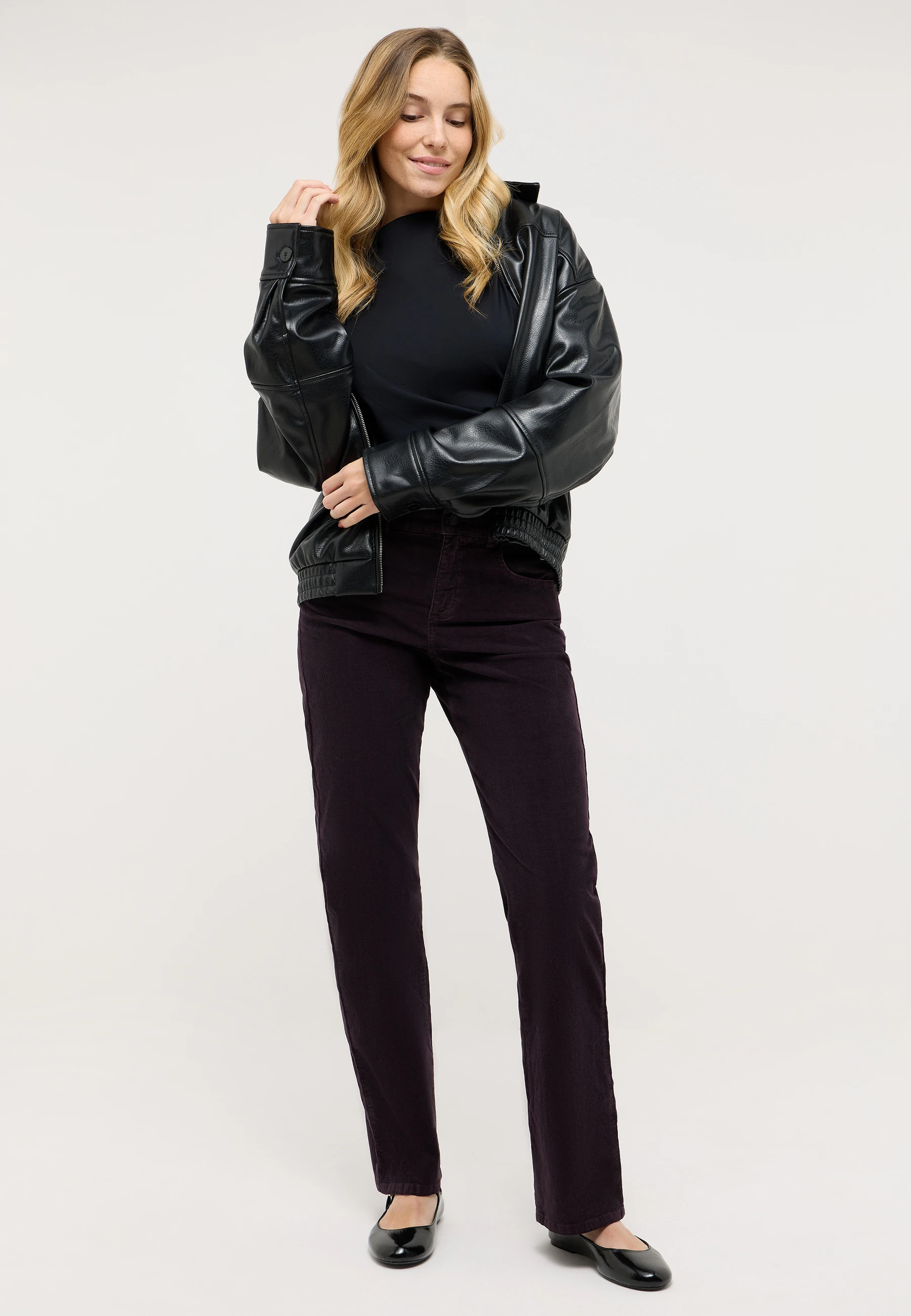 Model trägt weinrote ANGELS Cordhose mit Straight Fit und Lederjacke