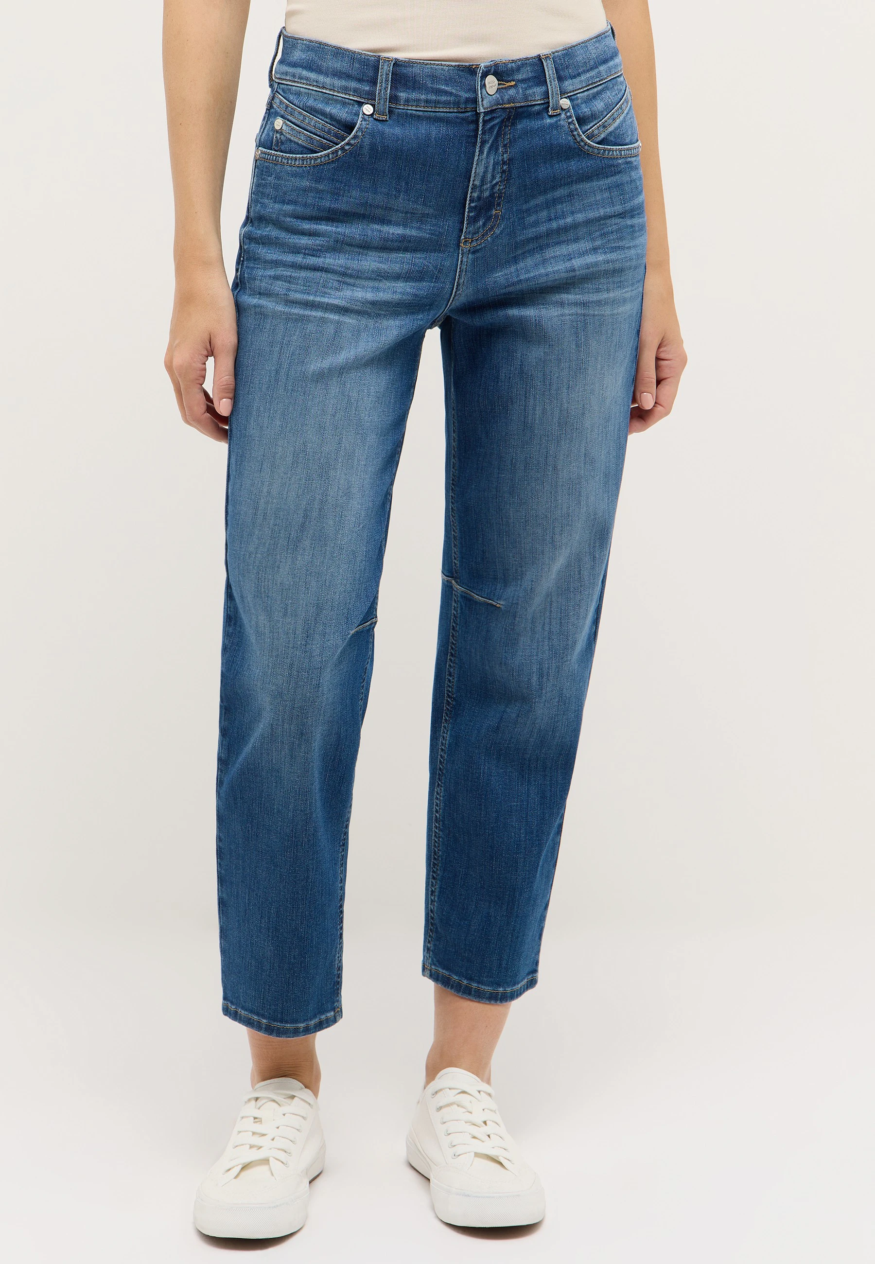 Detailansicht einer blauen ANGELS Cropped Jeans mit weißen Sneakern
