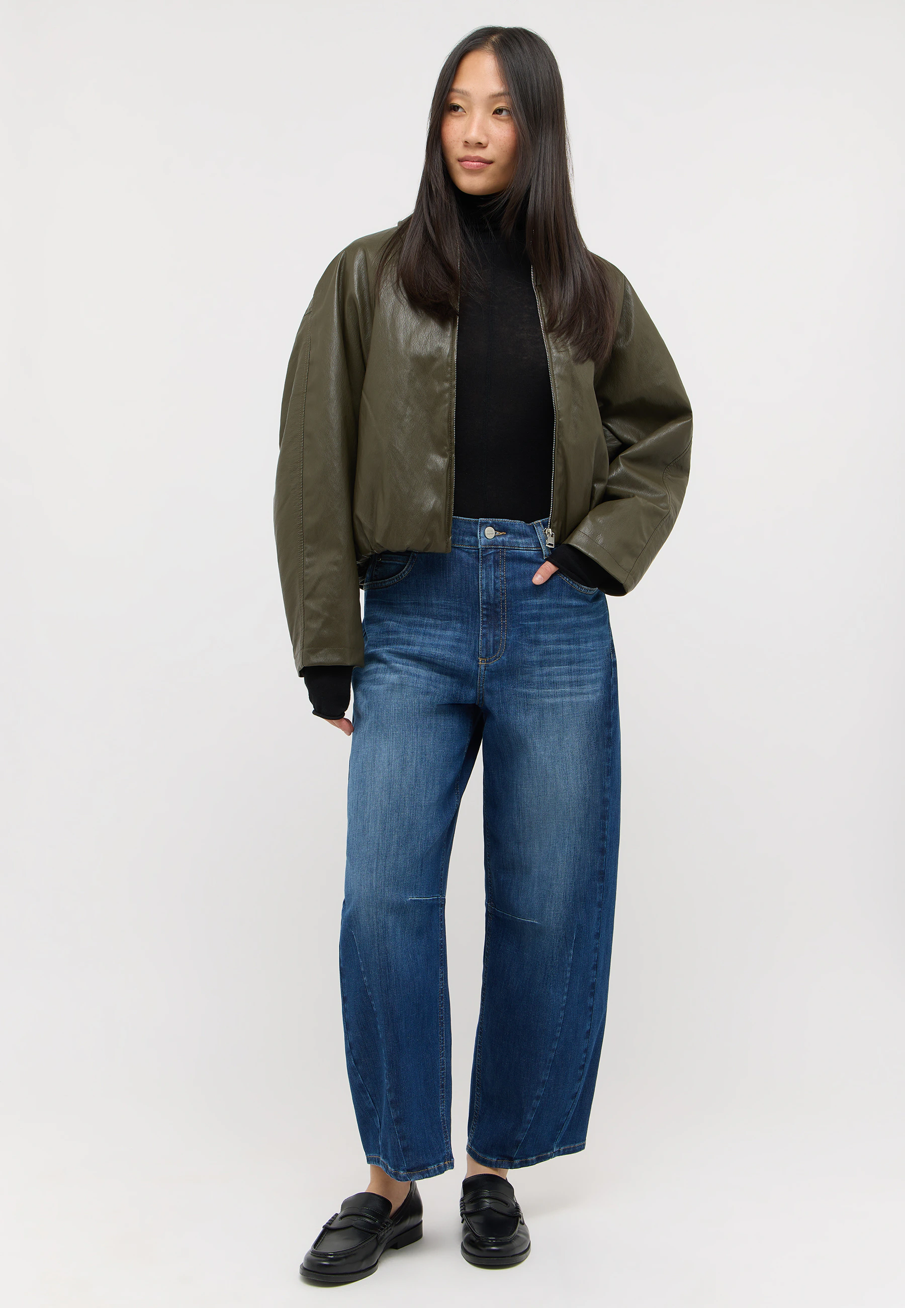 Frau trägt die Elly Jeans von Angels kombiniert mit grüner Lederjacke und Loafern