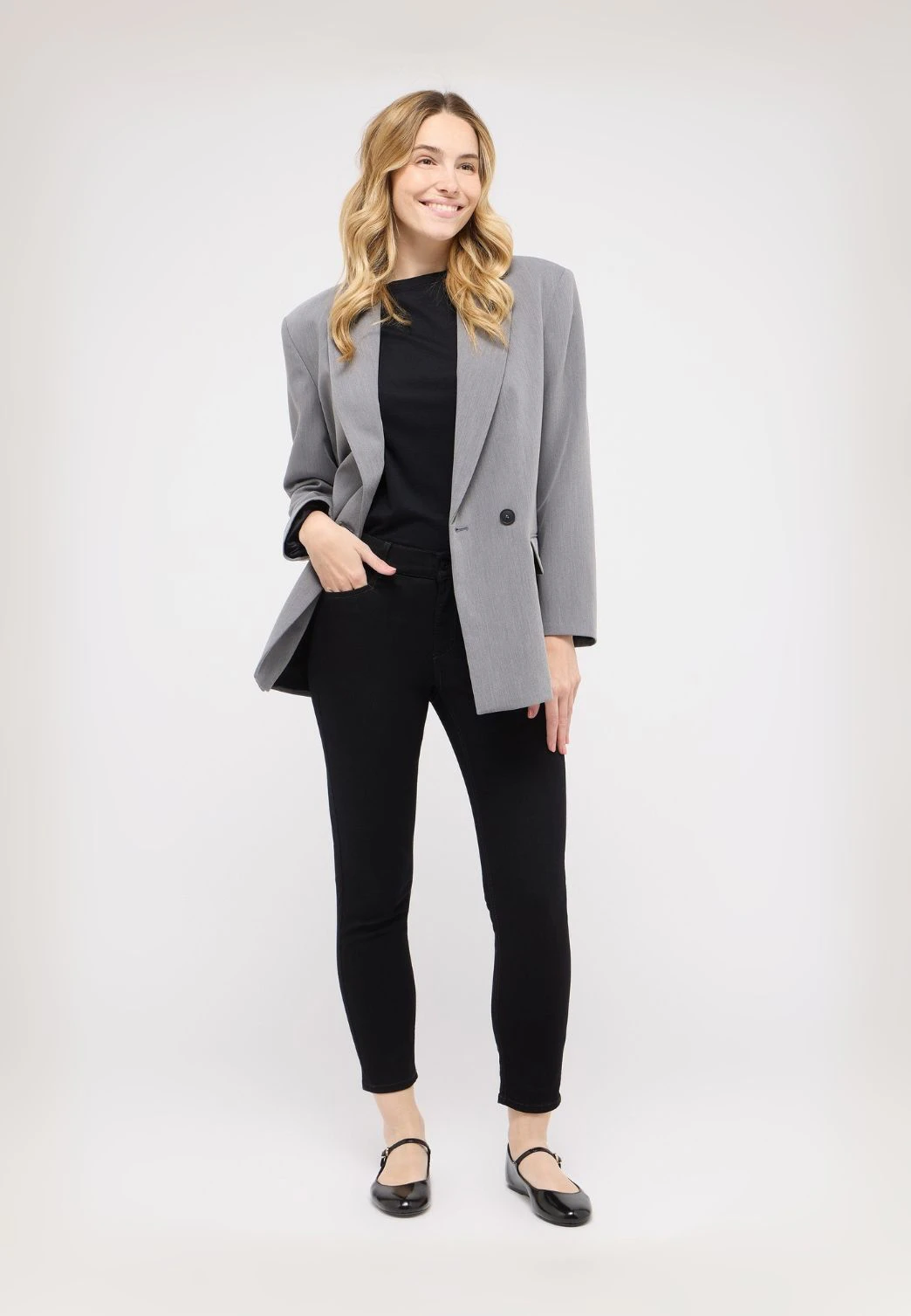 Frau in schwarzer Ornella Slim Fit Jeans und Blazer