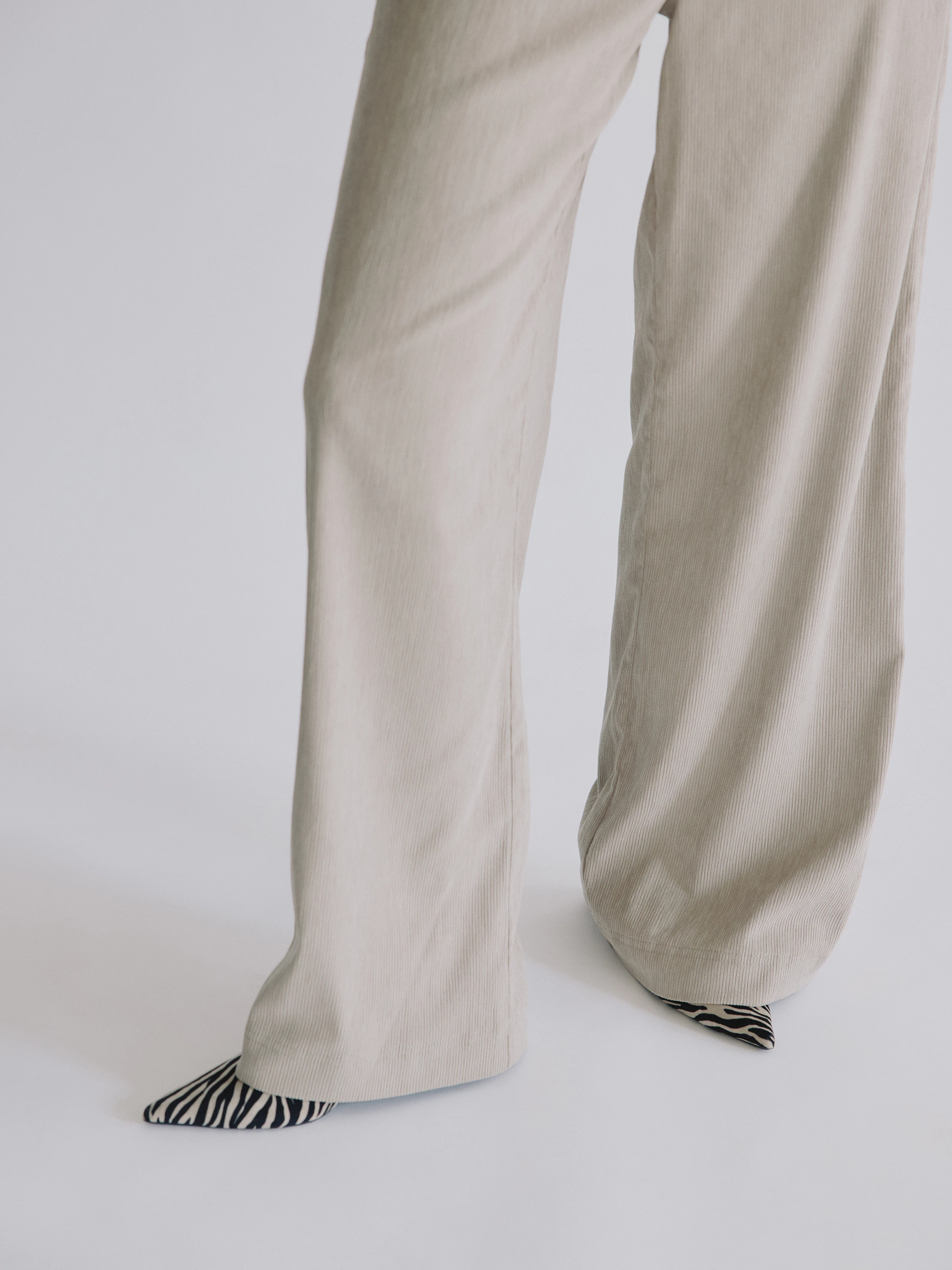 Bildausschnitt einer ANGELS Cordhose kombiniert mit spitzen Muster-Pumps