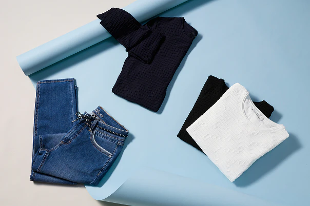 Basic Shirts liegend auf dem Boden und eine blaue Jeans.