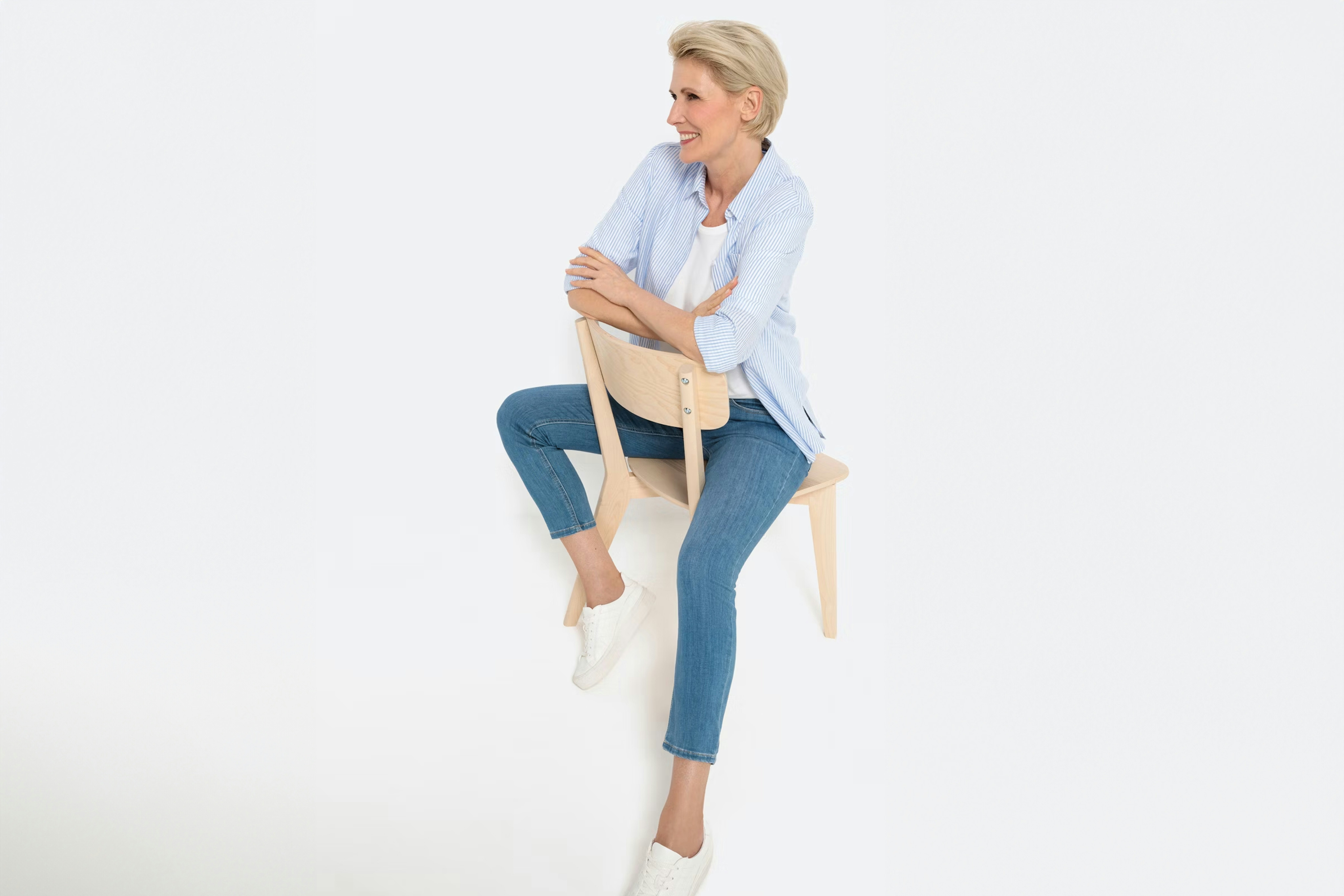 Vrouw in blauwe spijkerbroek en blauw-wit gestreepte blouse