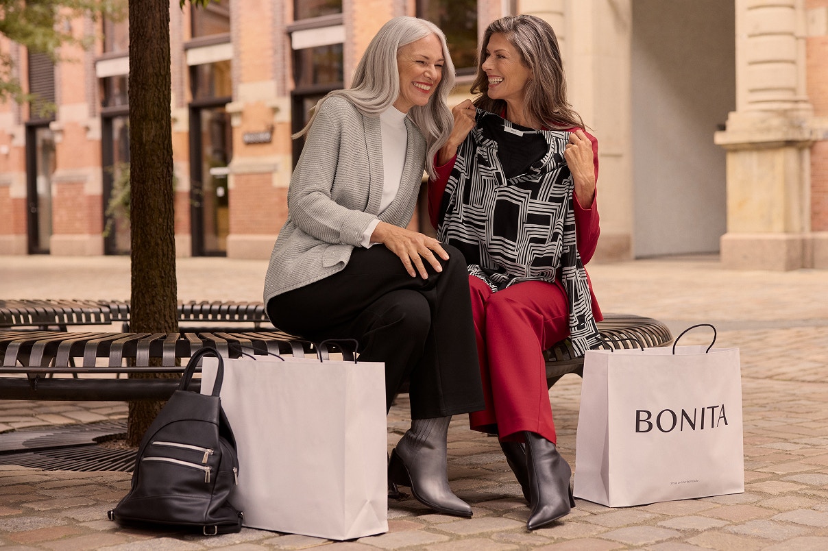 Twee vrouwen zittend op een bankje in  Bonita Nieuwigheden.  