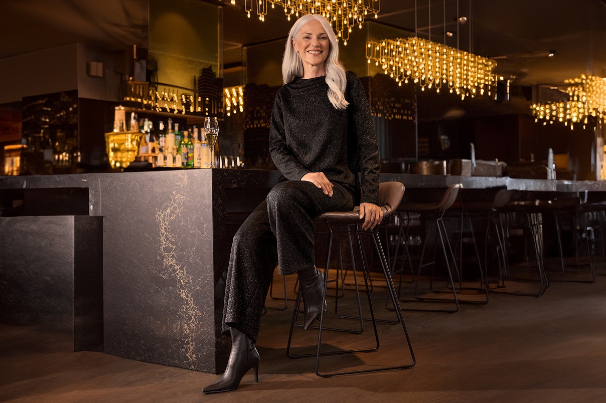 Een vrouw zittend op een stoel in een feestelijke Bonita-outfit.