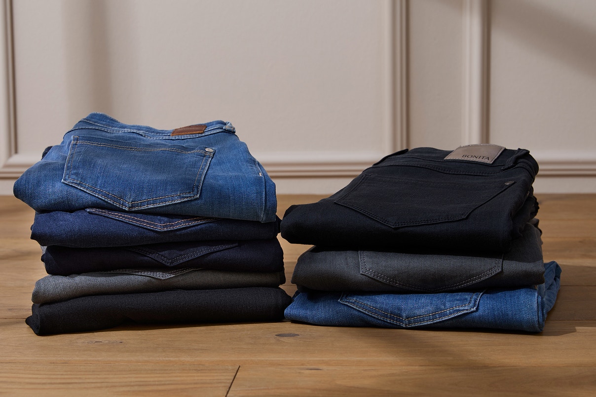 Zwei Jeansstapel auf einem Holzboden. 