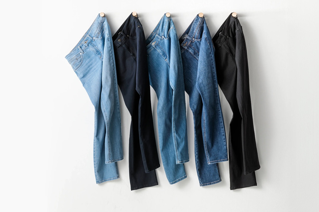 Verschiedene Jeanshosen hängend an der Wand.  