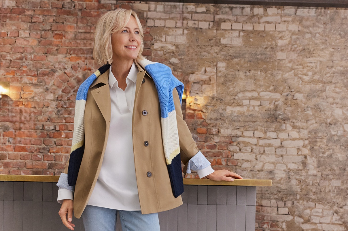 Eine Frau anlehnend an einer Theke in einem kompletten Bonita Outfit.