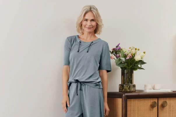 Eine Frau stehend in einem blauen Matching-Set. 