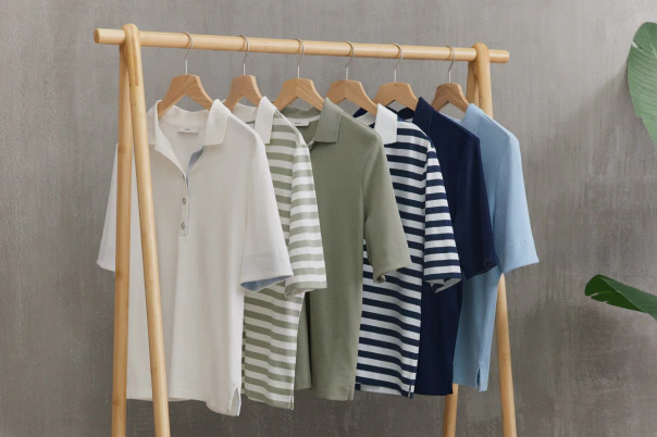Ein Holzständer mit verschiedenen Poloshirts. 