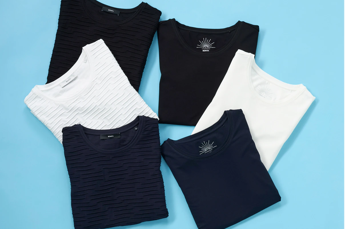 Verschillende basic-shirts op een blauwe achtergrond. 