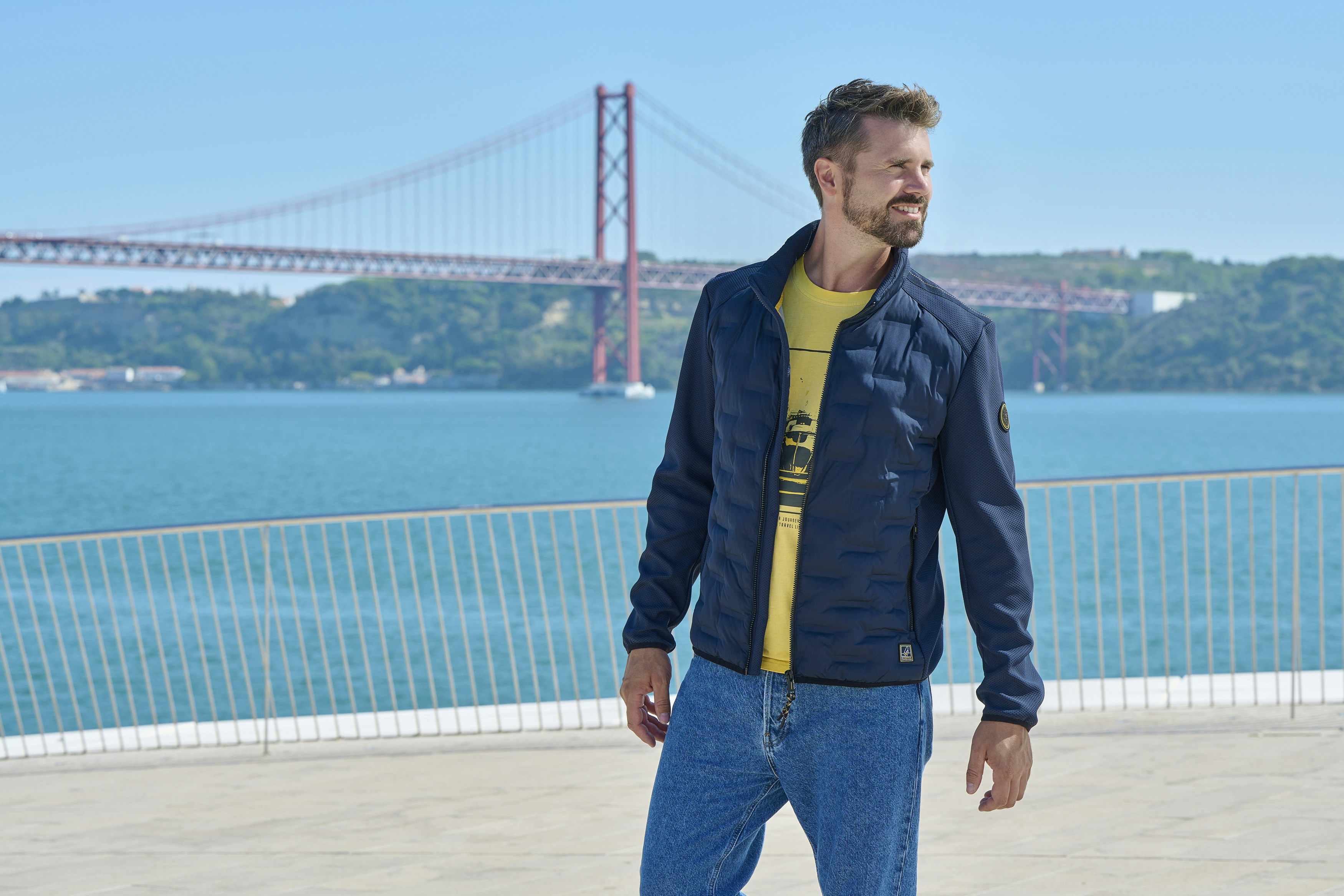 Thore Schölermann zeigt ein gelbes T-Shirt und eine blaue Materialmixjacke von Casamoda