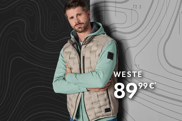 Thore Schölermann trägt eine beige Steppweste über einem mintgrünen Hoodie, kombiniert mit blauer Jeans.