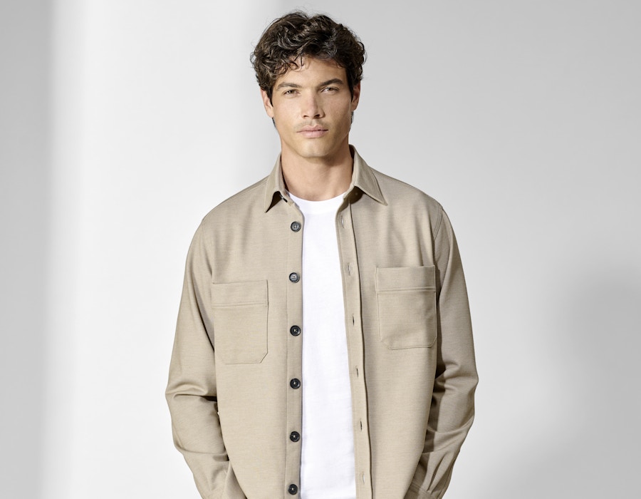 Ein junger Mann posiert mit einer beigen Hemdjacke von CASAMODA
