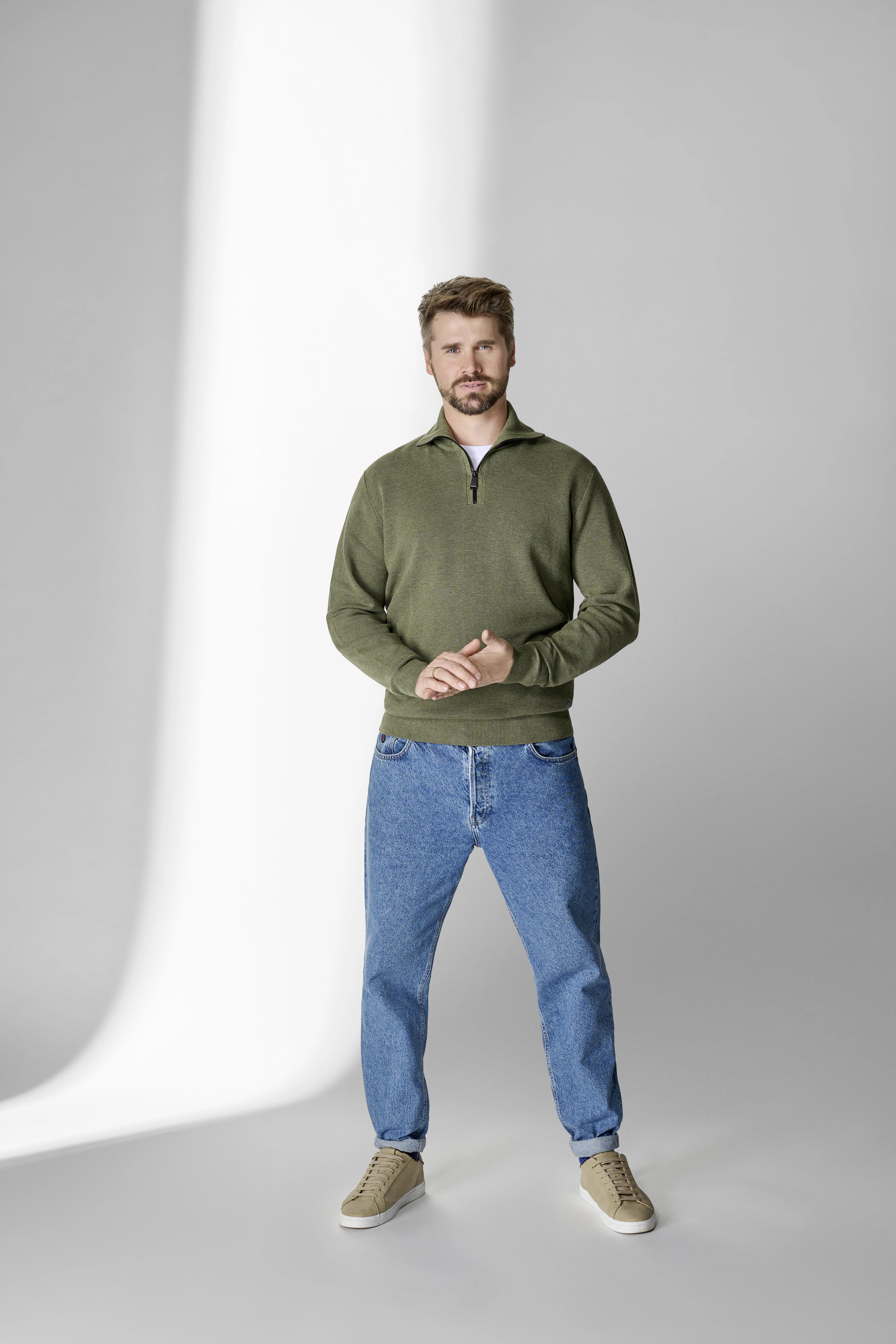 Thore Schölermann posiert mit einem grünen Sweatshirt von CASAMODA