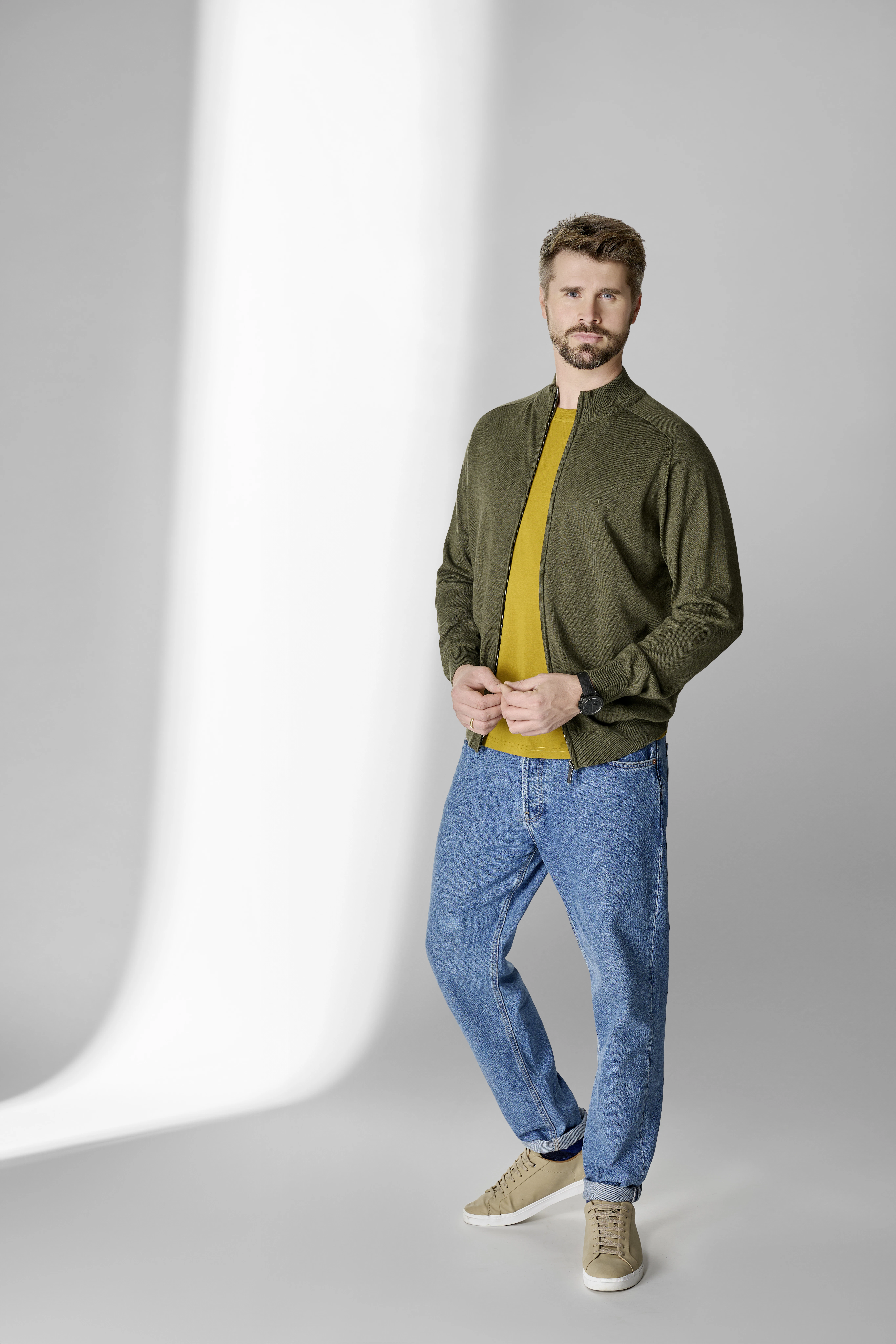 Thore Schölermann posiert mit einer grünen Jacke von CASAMODA