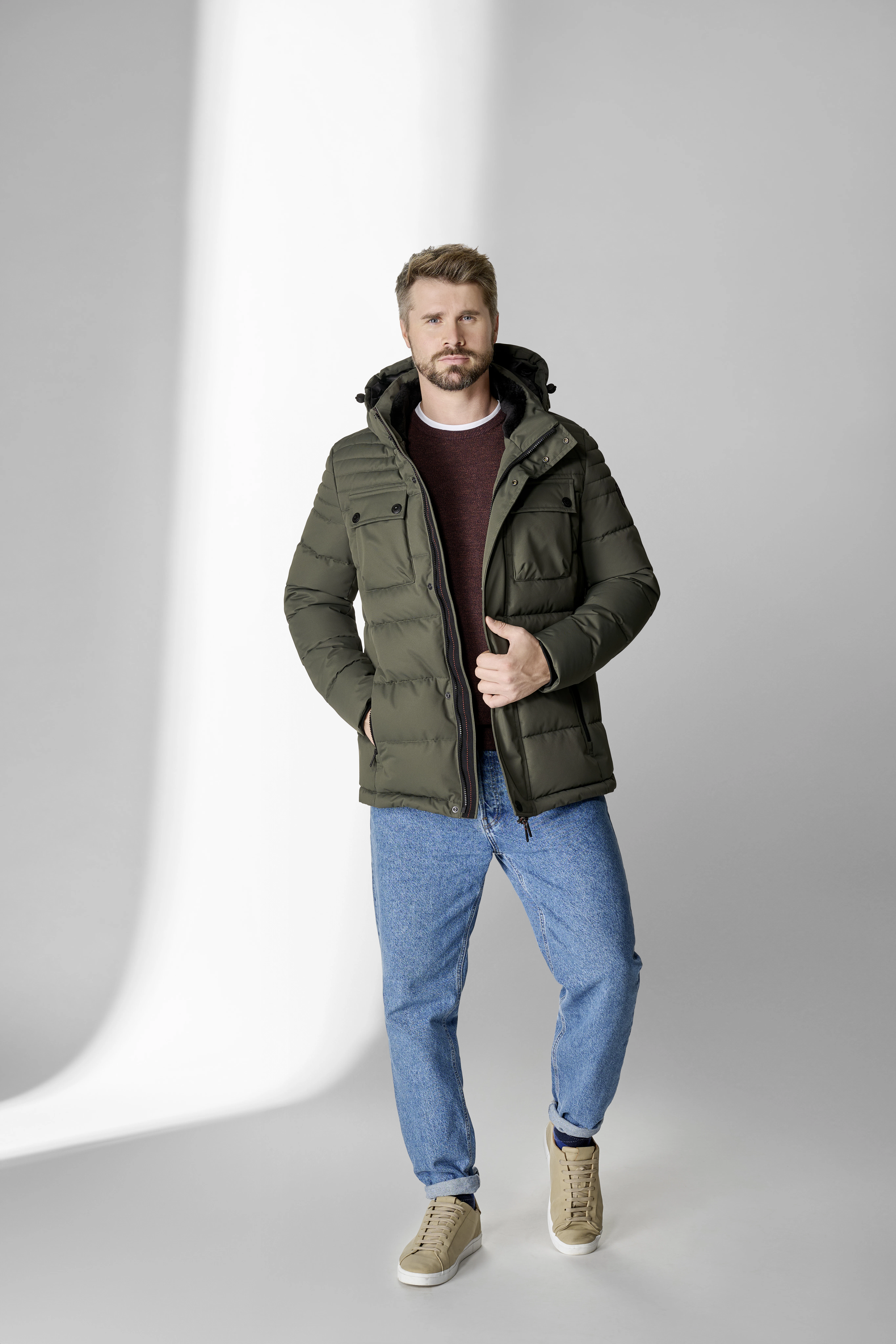 Thore Schölermann posiert mit einer grünen Herrenjacke von CASAMODA