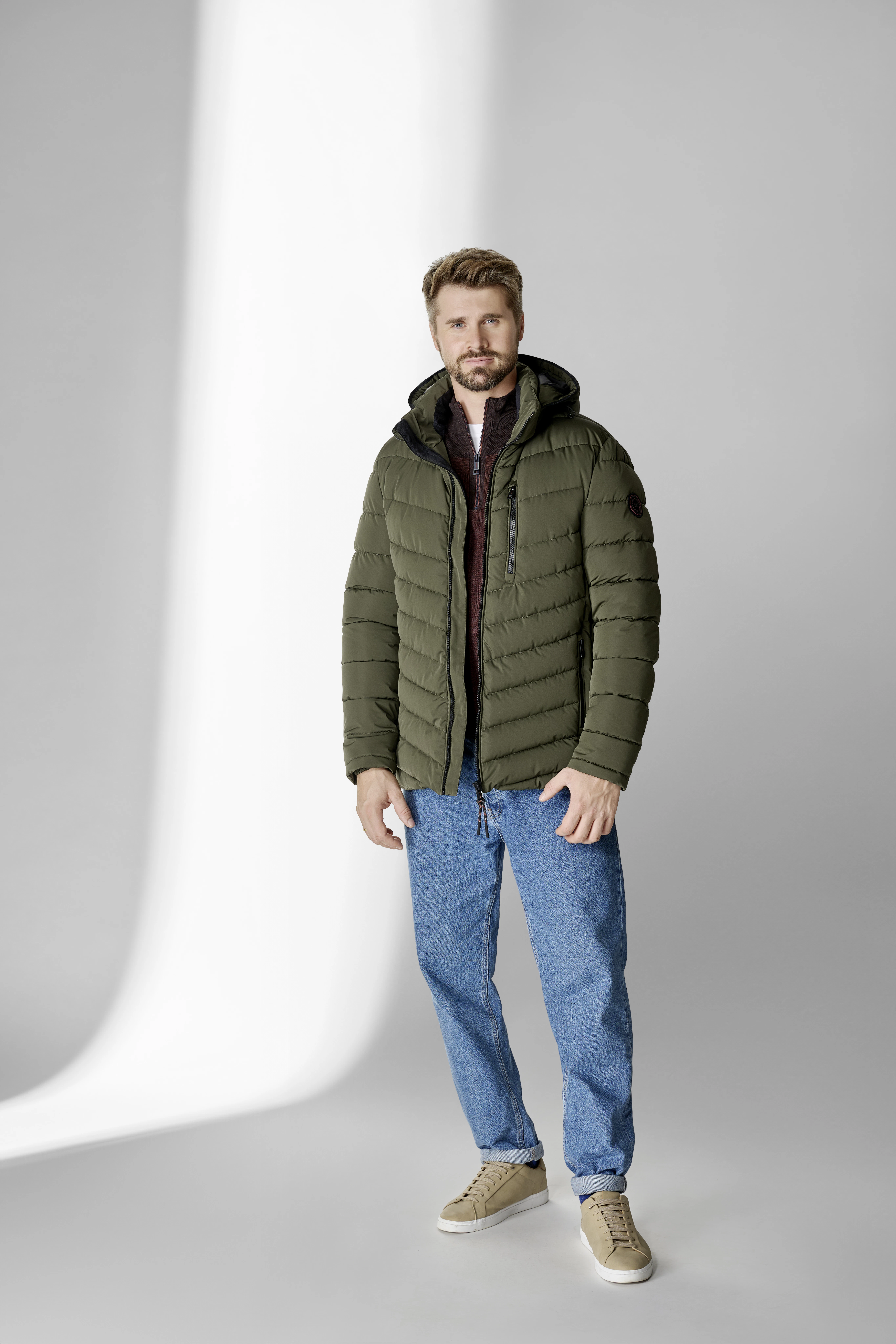 Thore Schölermann posiert mit einer grünen Herrenjacke von CASAMODA