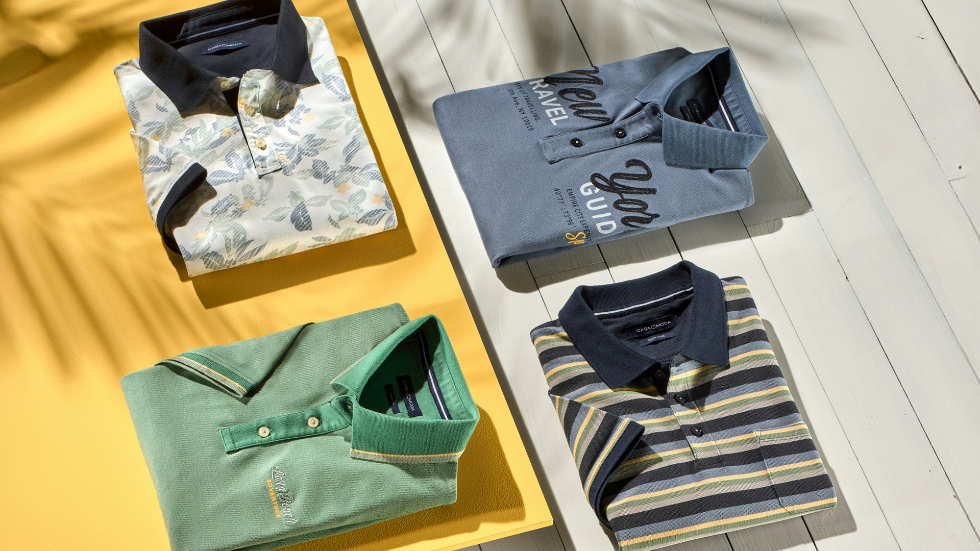 Poloshirts von CASAMODA liegen in verschiedenen Farben auf dem Tisch