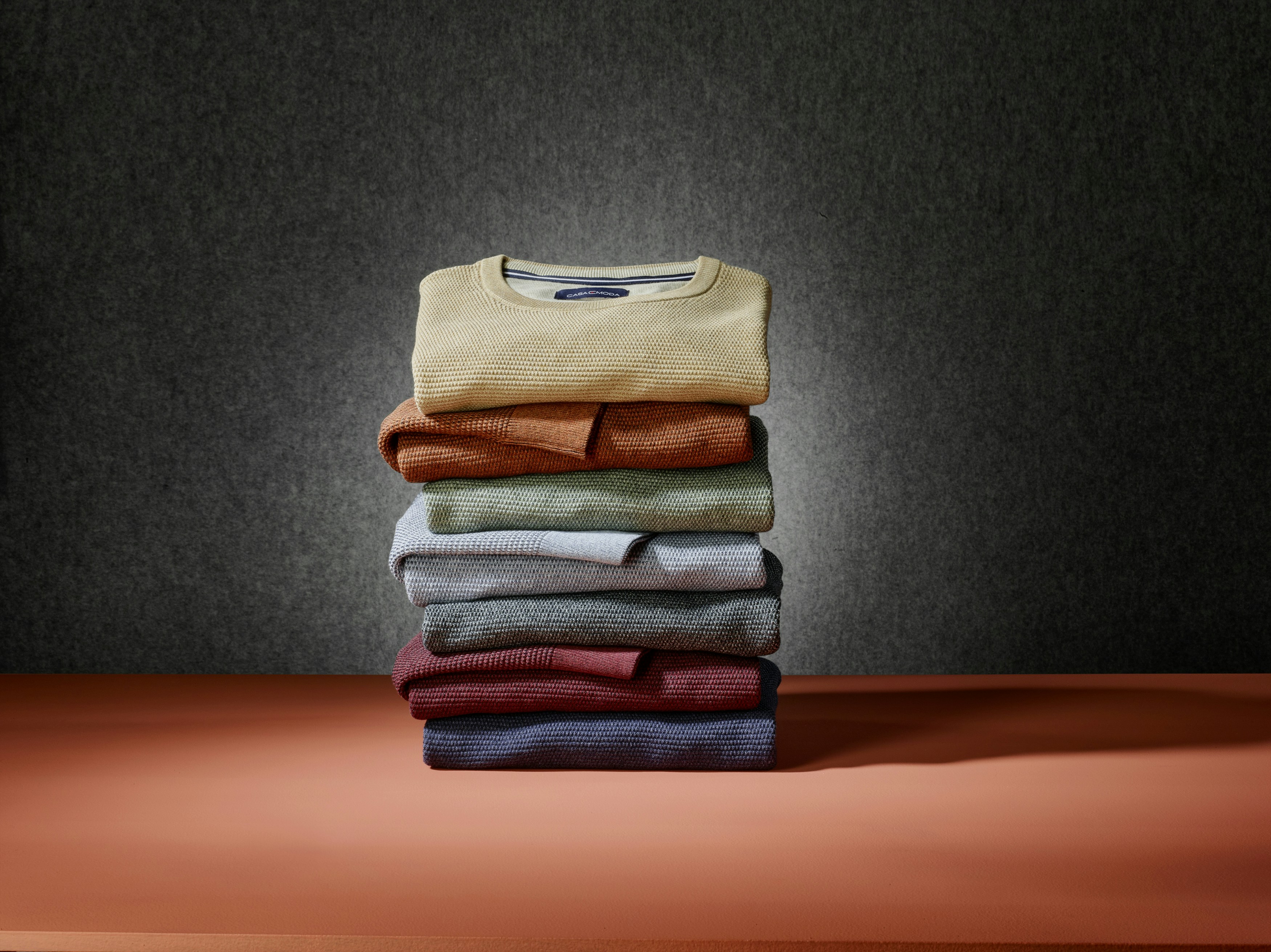 Ein Stapel an unterschiedlichen Pullovern von CASAMODA 