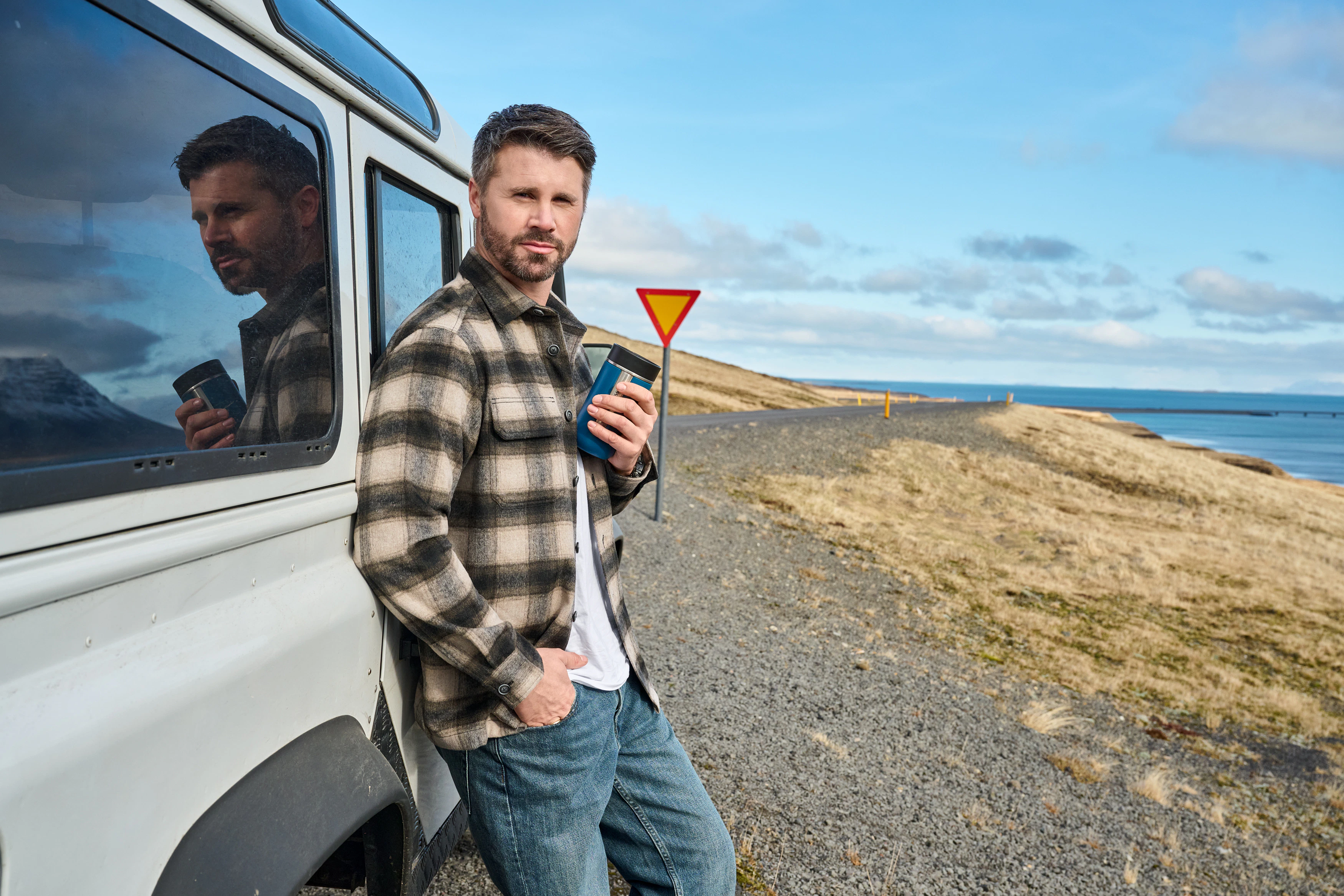 Thore Schölermann posiert neben einem weißen Auto