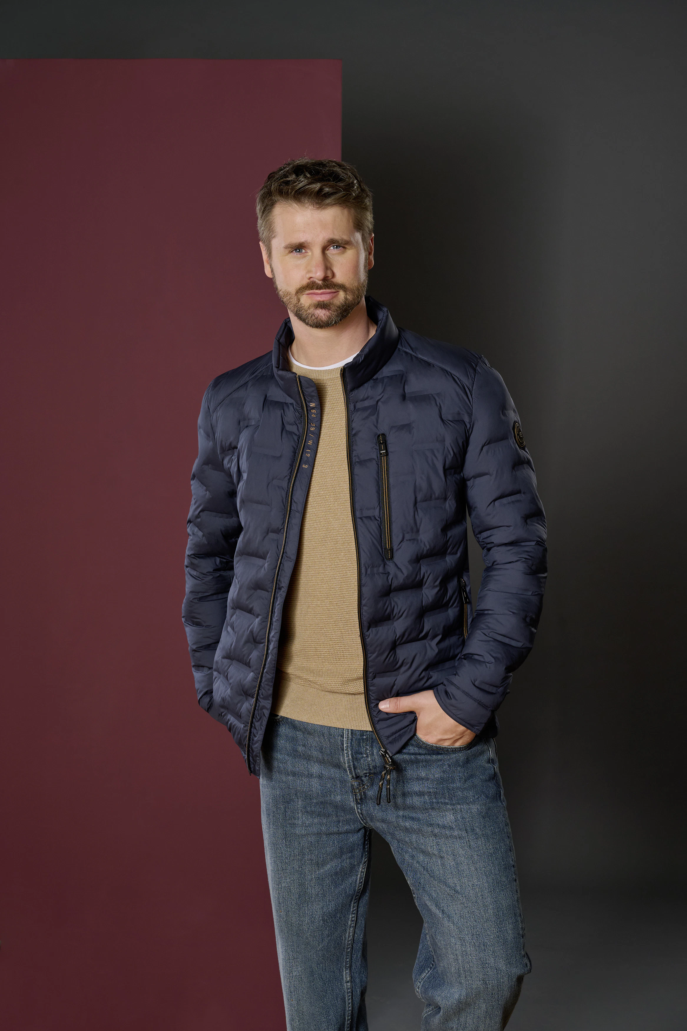 Thore Schölermann posiert mit einer blauen Steppjacke von CASAMODA