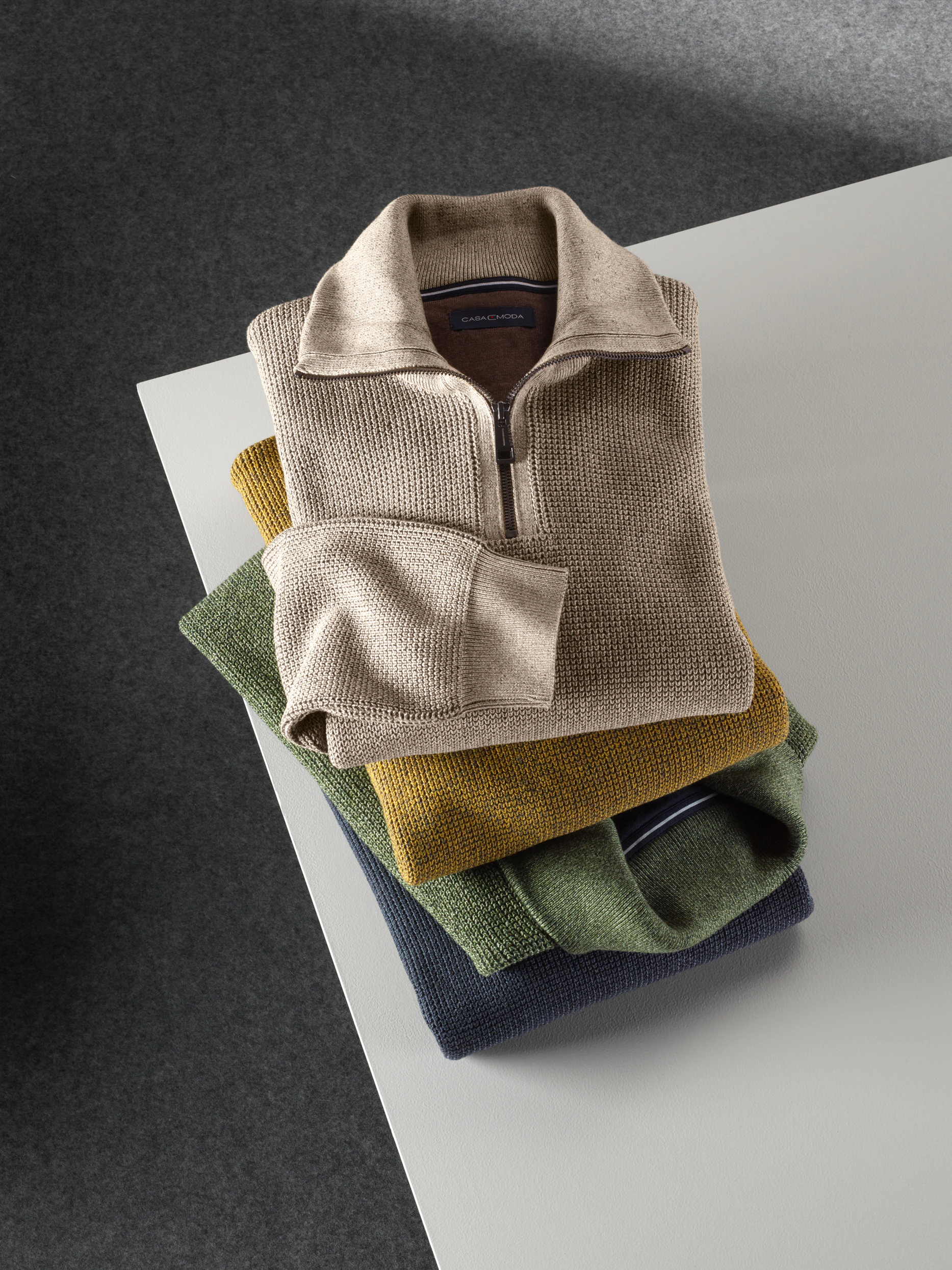 Ein Stapel mit Strickpullovern von CASAMODA