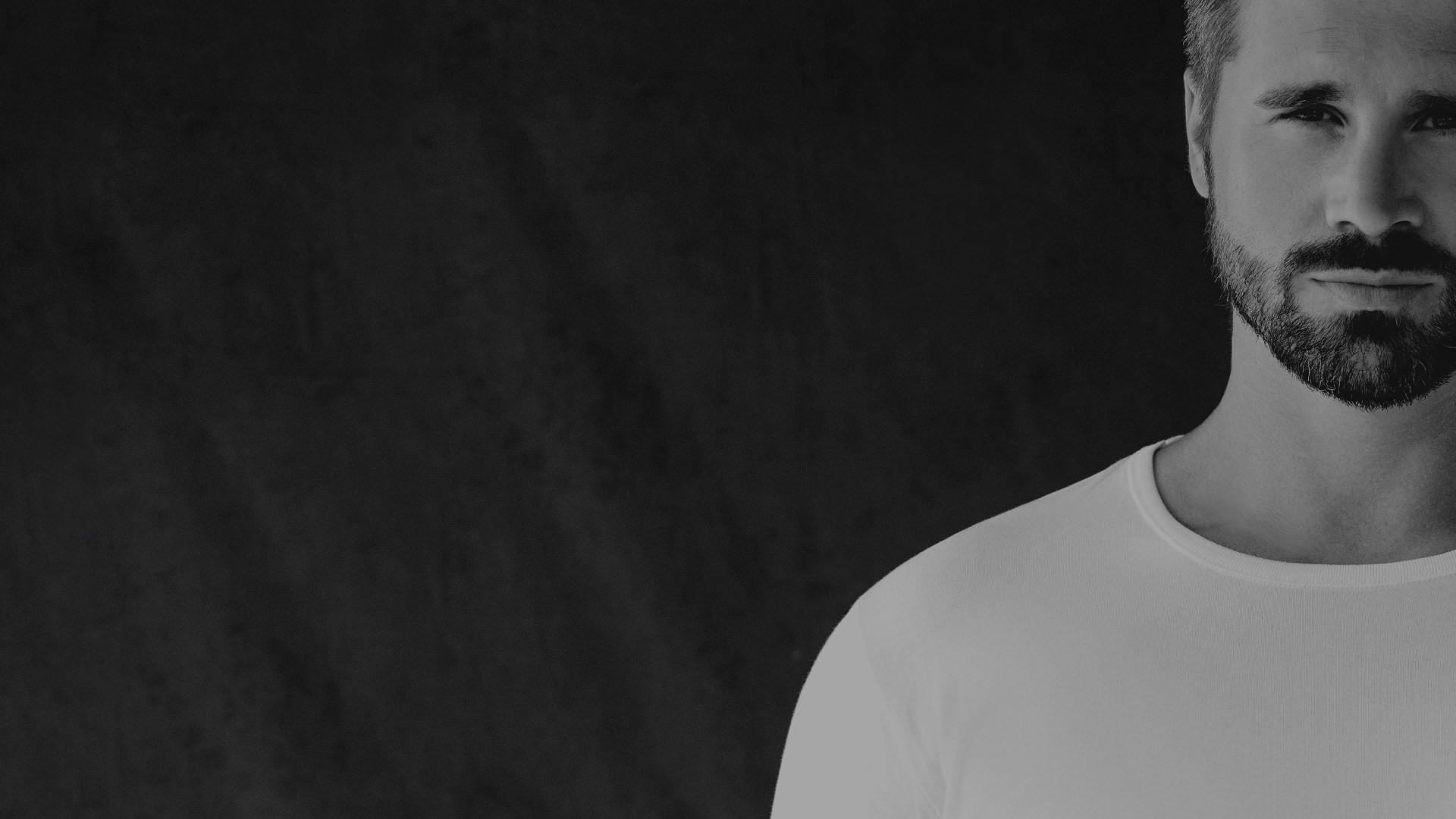 Thore Schölermann in einem weißen T-Shirt von CASAMODA mit schwarzem Overlayer