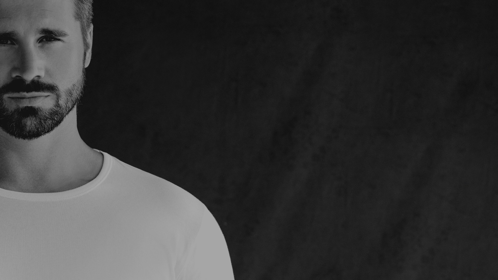 Thore Schölermann in einem weißen T-Shirt von CASAMODA mit schwarzem Overlayer