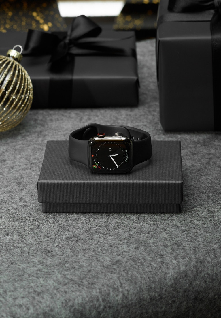 Apple Watch in schwarz liegend auf einer Geschenkbox