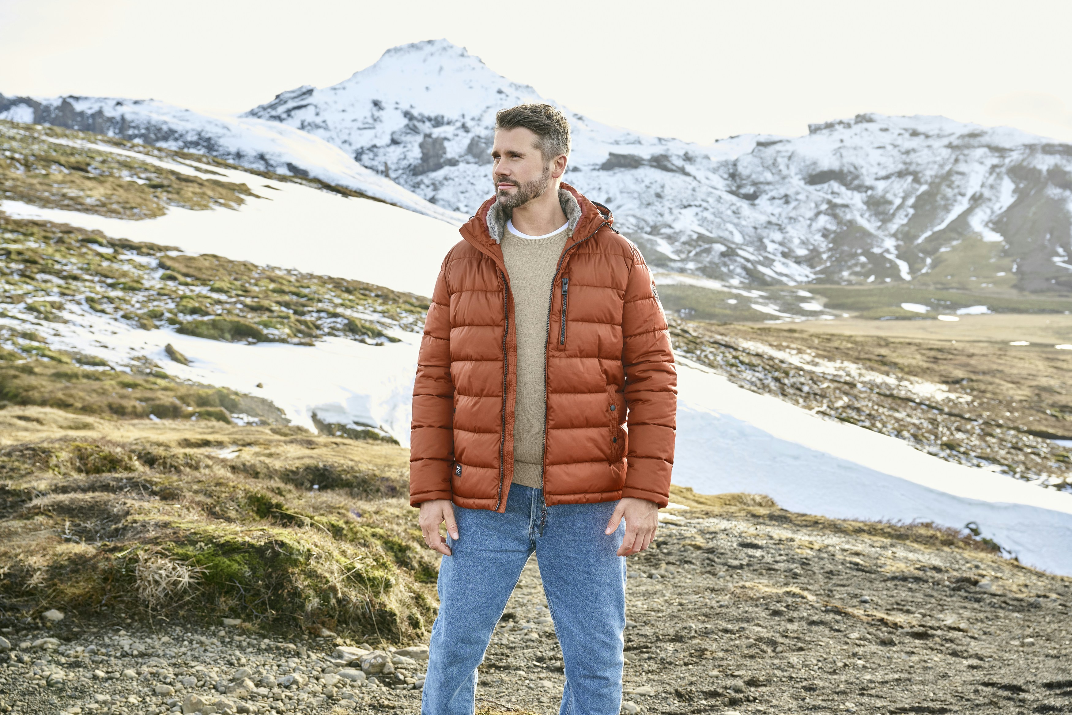 Thore Schölermann in einer Casamoda Steppjacke in verschneiter Berglandschaft