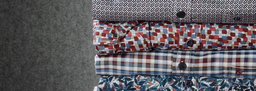 Stapel aus fünf Casamoda Hemden mit Mustern und Karos in warmen Farben