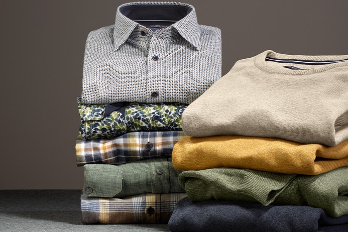 Zwei Stapel mit Freizeithemden und Pullovern von CASAMODA
