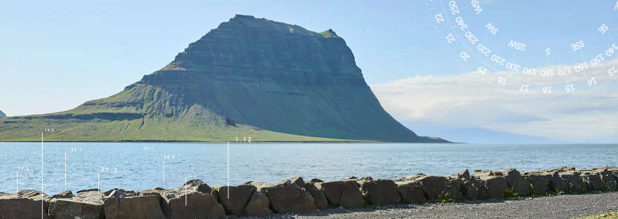 Wasser mit einem Berg im Hintergrund und einer Promenade im Vordergrund