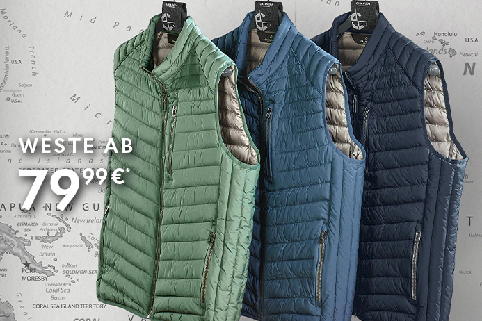 Mehrere gesteppte Westen in Grün, Blau und Dunkelblau hängen nebeneinander auf schwarzen Kleiderbügeln an einer Metallstange vor einer Wand mit Weltkartenmotiv.