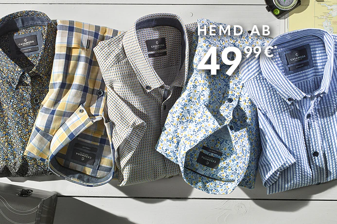 CASAMODA Herrenhemden: vier gemusterte Hemden auf hellem Holz, Kompass und Landkarte als Reise-Setting