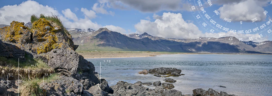 Küstenlandschaft mit Steinen und Wasser im Hintergrund