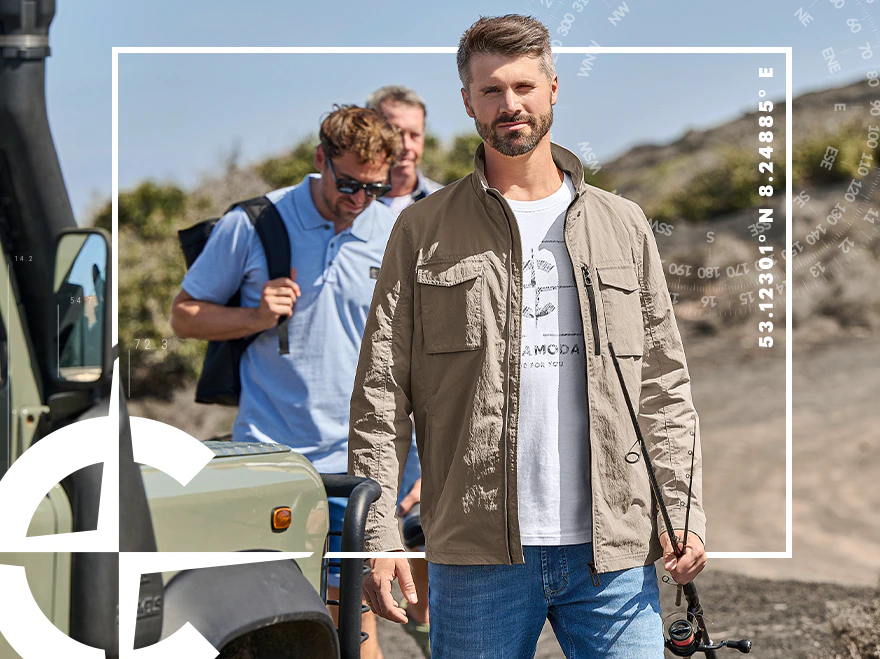 Herren Leichtjacke in Beige über Print-T-Shirt und Jeans bei einem Outdoor-Ausflug mit Geländewagen