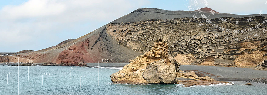 Küstenlandschaft mit markanter Felsformation, schwarzem Sandstrand und vulkanischem Hang am Meer