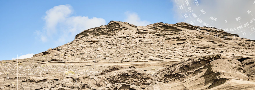 Hügelige Landschaft mit einem Berg im Hintergrund